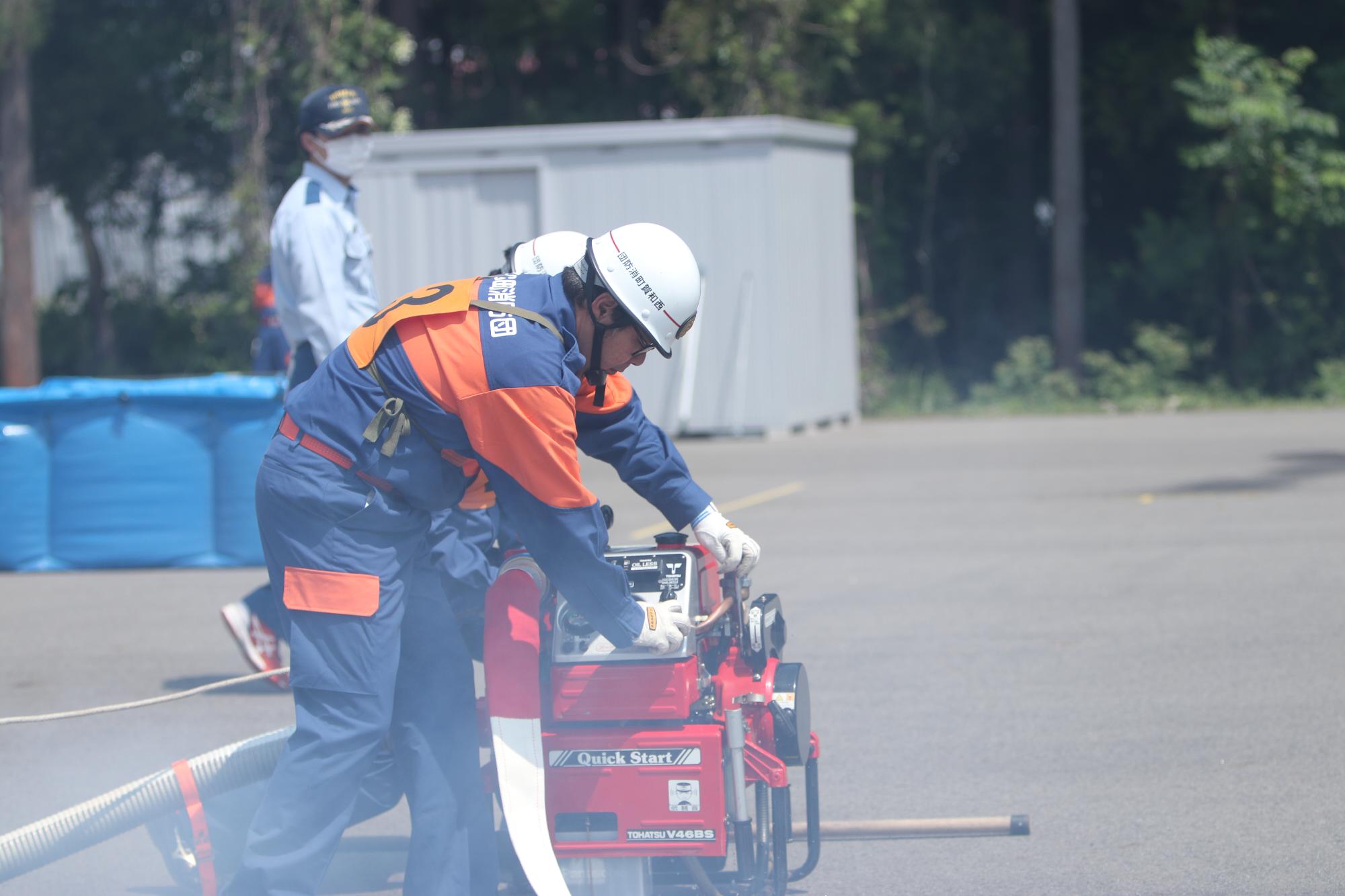 小型ポンプを操作する消防団員